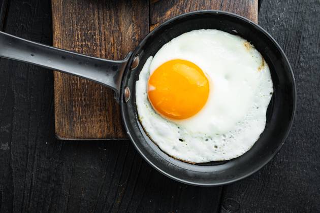 Fried Egg with ingredients in cast iron frying pan, on black wooden table background, top view flat lay Fried Egg with ingredient in cast iron frying pan, on black wooden table background, top view flat lay Copyright: xx 43659316