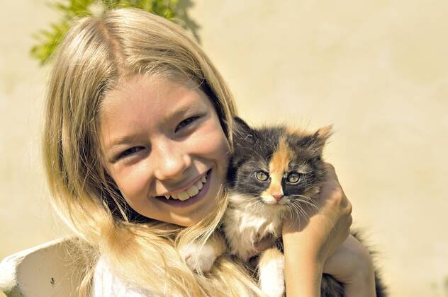 Hauskatze, Haus-Katze (Felis silvestris f. catus), kleines blondes Maedchen haelt gluecklich ein Kaetzchen in den Haenden, Portraet domestic cat, house cat (Felis silvestris f. catus), little blonde girl happily holding a kitten in her hands, portrait BLWS661202