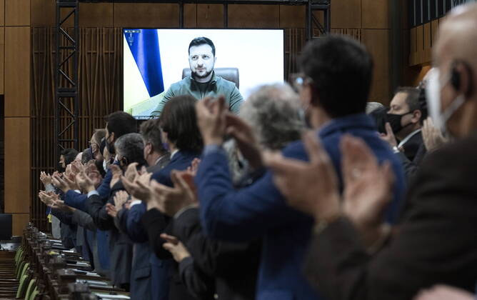 Bilder des Jahres 2022, News 03 März News Themen der Woche KW11 News Bilder des Tages March 15, 2022, Ottawa, ON, Canada: Canadian Members of Parliament and invited guests applaud as Ukrainian President Volodymyr Zelenskyy is shown on a giant video screen before addressing the Canadian parliament, Tuesday, March 15, 2022 in Ottawa. Ottawa Canada  - ZUMAc35_ 20220315_zaf_c35_001 Copyright: xAdrianxWyldx