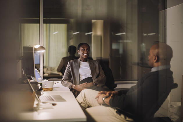 Smiling businesswoman planning strategy with male colleague seen through glass of work place Sweden, Stockholm, model released, property released Copyright: xMaskotx , MA92776