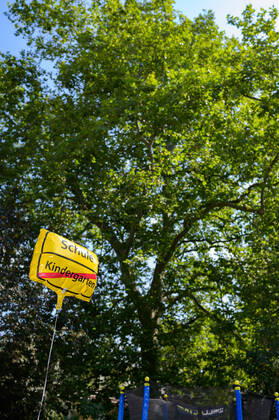 IMAGO Creative: Gesellschaft, Schule, Schulanfang An einer Schnur ist ein Luftballon befestigt. Auf dem Ballon steht Schule und durchgestrichen Kindergarten . Der Luftballon sieht aus wie ein Ortsschild.