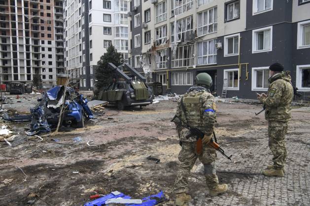 Ukraine-Krieg, Jahrestag der Invasion, Chronologie der Ereignisse, Archivbilder Ukraine-Konflikt, Eindrücke aus Butscha Situation In The Recaptured By The Ukrainian Army Bucha City Near Kyiv, Ukraine Ukrainian servicemen stands near Destroyed civil vehicles near a damaged residential building in the recaptured by the Ukrainian army Bucha city near Kyiv, Ukraine, 04 April 2022. Bucha Ukraine Copyright: xMaxymxMarusenkox originalFilename: musienko-notitle220404_npswt