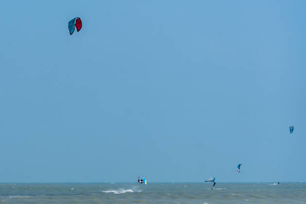 IMAGO Creative: Sommer Sport - Strand A kite surfer jumps out of the water while kiting in the Gulf of Mexico at South Padre Island, Texas. Other kite surfers and a wing surfer are nearby. South Padre Island Texas United States Copyright: xJonxG.xFullerx 7550-JGF-watersports-Kite Surfing-US-TX