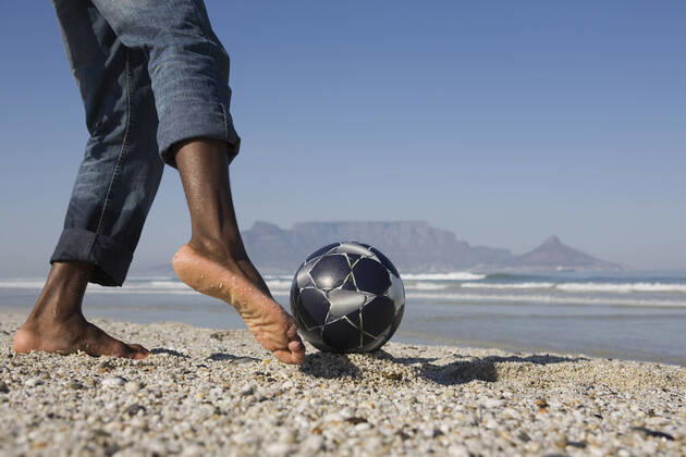 IMAGO Creative: Sommer Sport - Strand Young Man Playing Soccer On Beach, model released, , 10115932.jpg, Active, Activity, Adult, African, American, Ball, Barefoot, Beach, Black, Blue, Closeup, Coastline, Copyspace, Denim, Exercise, Feet, Fitness, Foot, Football, Health, Horizontal, Jeans, Legs, Leisure, Lowsection, Man, Mountain, Nature, Ocean, One, Outdoors, Person, Playing, Practising, Recreation, Rolled Up, Sand, Sea, Shore, Side View, Sky, Soccer, South Africa, Sport, Summer, Sunny, Training, Vitality, Young, 30s,