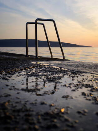 IMAGO Creative: 2022 Favoriten IMAGO Creative: Sommer Sport - Strand Ladder into the sea at the beach in Cres (Croatia), sunset in springtime, reflections in puddle Cres Croatia