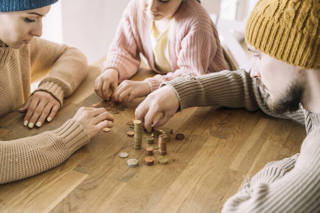Poor family with winter hats sitting at table counting coins model released, Symbolfoto property released, KMKF01841