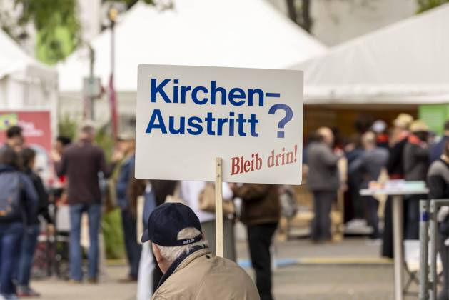 Zwei demonstranten gegen den Kirchenaustritt. 102. Deutscher Katholikentag in Stuttgart. Die fünftägige Veranstaltung steht unter dem Leitwort Leben teilen . Das Themenspektrum des Katholikentages reicht von Klimagerechtigkeit über Flucht bis Kirchenreform. In der gesamten Innenstand boten Infostände kirchlicher Gruppen Informationen und Diskussionen. 26.05.2022: Deutschland, Baden-Württemberg, Stuttgart.