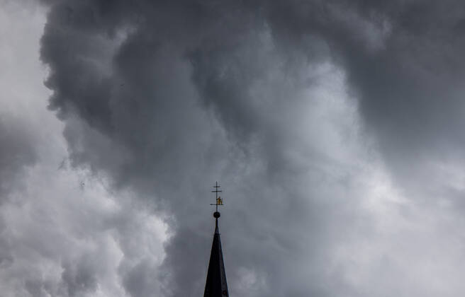 Dunkle Wolken über dem Kirchturm Dunkle Wolken eines Schauers sind am Abend am Himmel über dem Kirchturm der katholischen Kirche St.-Ursula in Oberursel zu sehen., Oberursel Hessen Deutschland