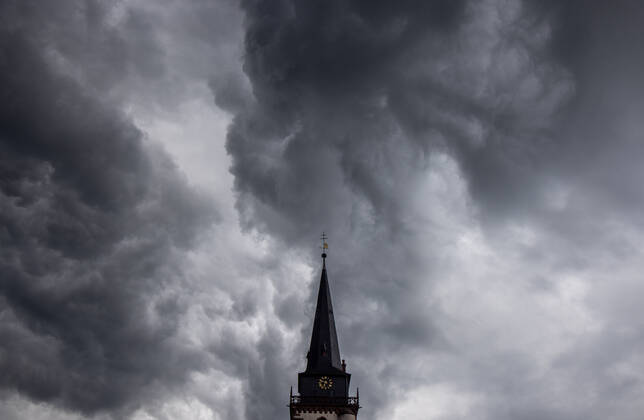 Dunkle Wolken über dem Kirchturm Dunkle Wolken eines Schauers sind am Abend am Himmel über dem Kirchturm der katholischen Kirche St.-Ursula in Oberursel zu sehen., Oberursel Hessen Deutschland