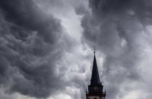 Dunkle Wolken über dem Kirchturm Dunkle Wolken eines Schauers sind am Abend am Himmel über dem Kirchturm der katholischen Kirche St.-Ursula in Oberursel zu sehen., Oberursel Hessen Deutschland