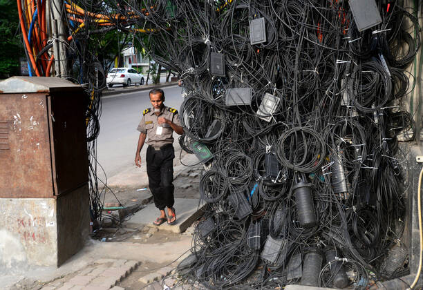 Bilder des Jahres 2022, News 06 Juni News Themen der Woche KW23 News Bilder des Tages Daily Life In Dhaka People walk through the scattered internet and satellite connection cables hanging on footpath in Dhaka, Bangladesh, on June 10, 2022. Dhaka Bangladesh  Copyright: xSTRx originalFilename: rashid-notitle220610_np7Am.jpg