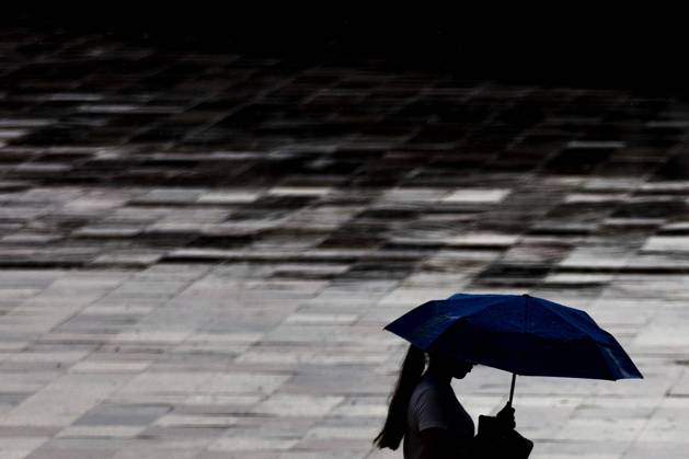 IMAGO Creative: Ende des Sommers Eine Frau mit Regenschirm zeichnet sich ab in Tirana, 29.05.2022. Tirana Albanien