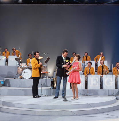 DREI MAL NEUN Drei mal Neun, ZDF Quizshow, Deutschland, 1971, im Bild: Max Greger mit Bigband, Showmaster Wim Thoelke und Trompetensolistin Carole Dawn Reinhart. Drei mal Neun, TV quiz show, Germany, 1971, on the photo: Max Greger and his Big band, presenter Wim Thoelke and the American trumpet soloist Carole Dawn Reinhart, Deutschland Copyright: ArthurxGrimm UnitedArchives82007901 EDITORIAL USE ONLY