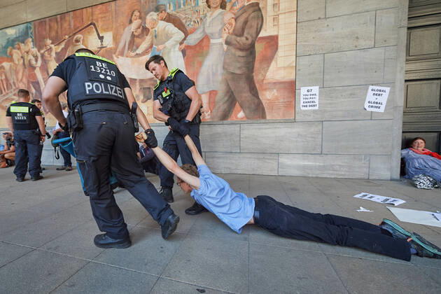 Bilder des Jahres 2022, News 06 Juni News Themen der Woche KW26 News Bilder des Tages Ein Demonstrant will sich nicht wegtragen lassen und wird an den Armen vom Haupteingang weggezogen waehrend Aktivist:innen der Klimaschutzinitiative Debt for Climate am 27.06.2022 Zugaenge des Bundesfinanzministeriums in Berlin blockieren (Foto). Anlaesslich des G7 Gipfels in Elmau kuendigten mehrere Gruppen globaler Klimagerechtigkeitsbewegungen Aktionen zivilen Ungehorsams an, um einen Schuldenerlass fuer Laender des globalen Suedens einzufordern. Die Aktion ist Teil der globalen Graswurzel-Initiative Debt for Climate , welche von Arbeits-, sozialen und Klima-Bewegungen des Globalen Suedens angefuehrt wird. (Siehe epd-Meldung vom 27.06.2022) Aktivist:innen der Klimaschutzinitiative Debt for Climate blockieren Zugaenge des Bundesfinanzmin Copyright: epd-bild ChristianxDitsch EDITORIAL USE ONLY