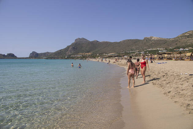Tourism In Greece - Falassarna Beach In Crete Island Tourism in Greece - The exotic beach of Falassarna at the western side of Crete island. Falasarna bay with 5 beaches with whitish sand and crystal clear transparent tropical turquoise water hosts some of the most famous beaches in Greece, which has been awarded as the best beach of Crete and voted as one of the 10 best beaches in Europe several times in the past. Local people and tourists are seen relaxing, sunbathing, tanning, swimming, doing water sports and walking. Tourism is bouncing back with reservations exceeding the pre-pandemic numbers, putting Greece and the Greek islands on high demand. Tourists travel after the Covid-19 Coronavirus pandemic. Falassarna, Chania, Crete island, Copyright: xNicolasxEconomoux originalFilename: economou-tourismi220614_npKhn