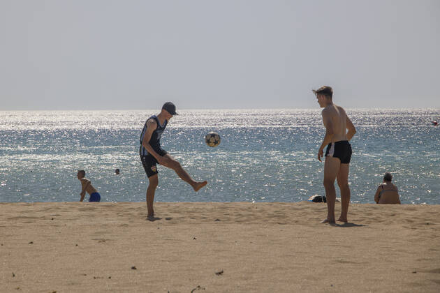Tourism In Greece - Falassarna Beach In Crete Island Tourism in Greece - Two young men play football at the beach. The exotic beach of Falassarna at the western side of Crete island. Falasarna bay with 5 beaches with whitish sand and crystal clear transparent tropical turquoise water hosts some of the most famous beaches in Greece, which has been awarded as the best beach of Crete and voted as one of the 10 best beaches in Europe several times in the past. Local people and tourists are seen relaxing, sunbathing, tanning, swimming, doing water sports and walking. Tourism is bouncing back with reservations exceeding the pre-pandemic numbers, putting Greece and the Greek islands on high demand. Tourists travel after the Covid-19 Coronavirus pa Copyright: xNicolasxEconomoux originalFilename: economou-tourismi220614_npaq2