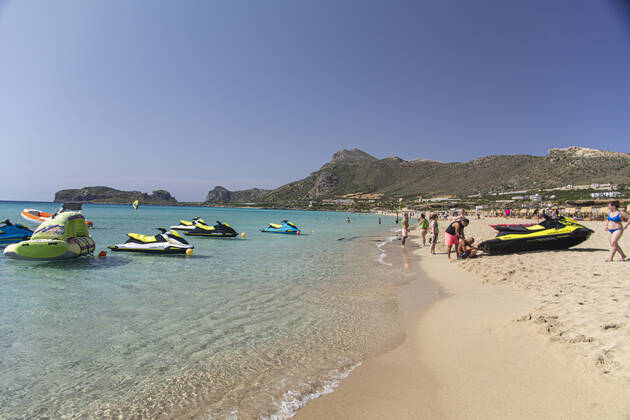 Tourism In Greece - Falassarna Beach In Crete Island Tourism in Greece - The exotic beach of Falassarna at the western side of Crete island. Falasarna bay with 5 beaches with whitish sand and crystal clear transparent tropical turquoise water hosts some of the most famous beaches in Greece, which has been awarded as the best beach of Crete and voted as one of the 10 best beaches in Europe several times in the past. Local people and tourists are seen relaxing, sunbathing, tanning, swimming, doing water sports and walking. Tourism is bouncing back with reservations exceeding the pre-pandemic numbers, putting Greece and the Greek islands on high demand. Tourists travel after the Covid-19 Coronavirus pandemic. Falassarna, Chania, Crete island, Copyright: xNicolasxEconomoux originalFilename: economou-tourismi220614_npOvH