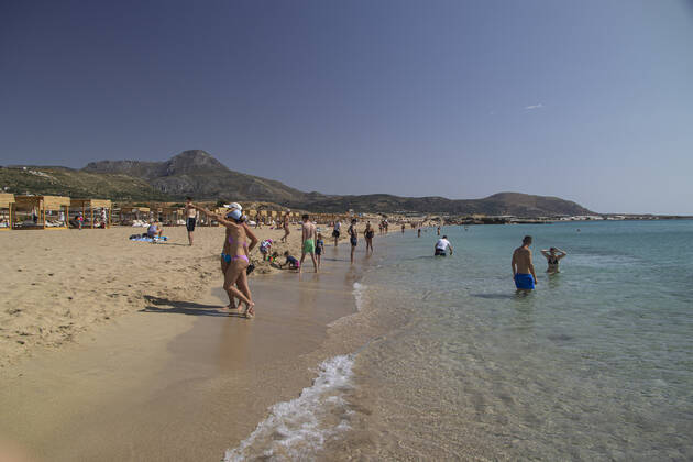 Tourism In Greece - Falassarna Beach In Crete Island Tourism in Greece - The exotic beach of Falassarna at the western side of Crete island. Falasarna bay with 5 beaches with whitish sand and crystal clear transparent tropical turquoise water hosts some of the most famous beaches in Greece, which has been awarded as the best beach of Crete and voted as one of the 10 best beaches in Europe several times in the past. Local people and tourists are seen relaxing, sunbathing, tanning, swimming, doing water sports and walking. Tourism is bouncing back with reservations exceeding the pre-pandemic numbers, putting Greece and the Greek islands on high demand. Tourists travel after the Covid-19 Coronavirus pandemic. Falassarna, Chania, Crete island, Copyright: xNicolasxEconomoux originalFilename: economou-tourismi220614_npqFA