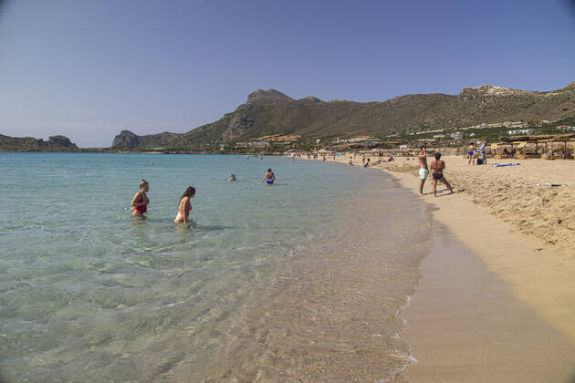 Tourism In Greece - Falassarna Beach In Crete Island Tourism in Greece - The exotic beach of Falassarna at the western side of Crete island. Falasarna bay with 5 beaches with whitish sand and crystal clear transparent tropical turquoise water hosts some of the most famous beaches in Greece, which has been awarded as the best beach of Crete and voted as one of the 10 best beaches in Europe several times in the past. Local people and tourists are seen relaxing, sunbathing, tanning, swimming, doing water sports and walking. Tourism is bouncing back with reservations exceeding the pre-pandemic numbers, putting Greece and the Greek islands on high demand. Tourists travel after the Covid-19 Coronavirus pandemic. Falassarna, Chania, Crete island, Copyright: xNicolasxEconomoux originalFilename: economou-tourismi220614_npQqA