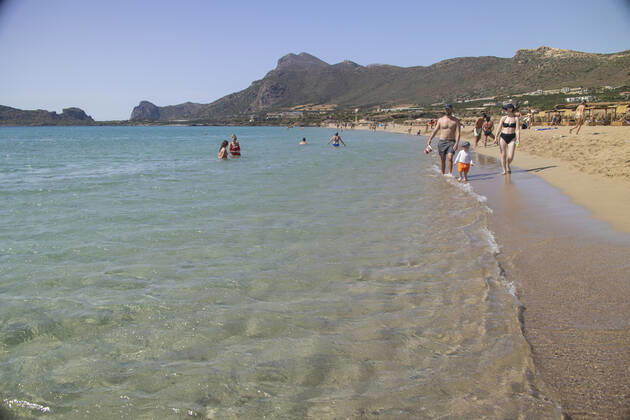 Tourism In Greece - Falassarna Beach In Crete Island Tourism in Greece - The exotic beach of Falassarna at the western side of Crete island. Falasarna bay with 5 beaches with whitish sand and crystal clear transparent tropical turquoise water hosts some of the most famous beaches in Greece, which has been awarded as the best beach of Crete and voted as one of the 10 best beaches in Europe several times in the past. Local people and tourists are seen relaxing, sunbathing, tanning, swimming, doing water sports and walking. Tourism is bouncing back with reservations exceeding the pre-pandemic numbers, putting Greece and the Greek islands on high demand. Tourists travel after the Covid-19 Coronavirus pandemic. Falassarna, Chania, Crete island, Copyright: xNicolasxEconomoux originalFilename: economou-tourismi220614_npUh7