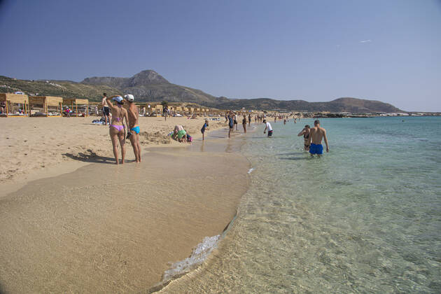 Tourism In Greece - Falassarna Beach In Crete Island Tourism in Greece - The exotic beach of Falassarna at the western side of Crete island. Falasarna bay with 5 beaches with whitish sand and crystal clear transparent tropical turquoise water hosts some of the most famous beaches in Greece, which has been awarded as the best beach of Crete and voted as one of the 10 best beaches in Europe several times in the past. Local people and tourists are seen relaxing, sunbathing, tanning, swimming, doing water sports and walking. Tourism is bouncing back with reservations exceeding the pre-pandemic numbers, putting Greece and the Greek islands on high demand. Tourists travel after the Covid-19 Coronavirus pandemic. Falassarna, Chania, Crete island, Copyright: xNicolasxEconomoux originalFilename: economou-tourismi220614_npzQM