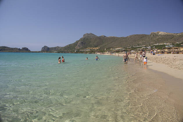 Tourism In Greece - Falassarna Beach In Crete Island Tourism in Greece - The exotic beach of Falassarna at the western side of Crete island. Falasarna bay with 5 beaches with whitish sand and crystal clear transparent tropical turquoise water hosts some of the most famous beaches in Greece, which has been awarded as the best beach of Crete and voted as one of the 10 best beaches in Europe several times in the past. Local people and tourists are seen relaxing, sunbathing, tanning, swimming, doing water sports and walking. Tourism is bouncing back with reservations exceeding the pre-pandemic numbers, putting Greece and the Greek islands on high demand. Tourists travel after the Covid-19 Coronavirus pandemic. Falassarna, Chania, Crete island, Copyright: xNicolasxEconomoux originalFilename: economou-tourismi220614_nptkG