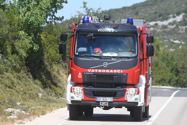 PXL_A fire near Vodice, Croatia Fire in an open area near the Velika Mrdakovica archaeological site in the Vodice hinterland, Croatia on July 13, 2022. About 30 firefighters with a dozen vehicles are on the ground, and two Canadairs joined the ground forces in extinguishing the fire. There are pine forests above, low vegetation, and endangered buildings. HrvojexJelavic PIXSELL