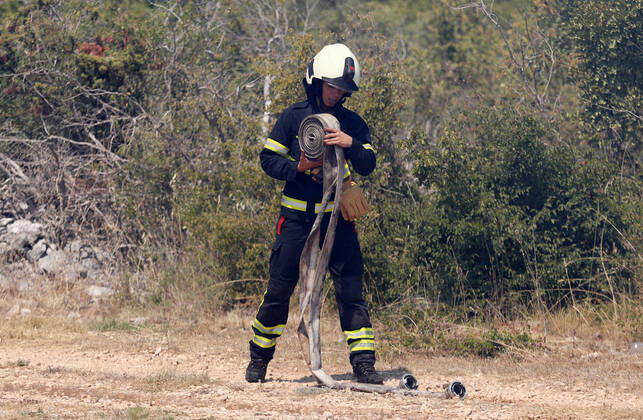PXL_A fire near Vodice, Croatia Fire in an open area near the Velika Mrdakovica archaeological site in the Vodice hinterland, Croatia on July 13, 2022. About 30 firefighters with a dozen vehicles are on the ground, and two Canadairs joined the ground forces in extinguishing the fire. There are pine forests above, low vegetation, and endangered buildings. DuskoxJaramaz PIXSELL
