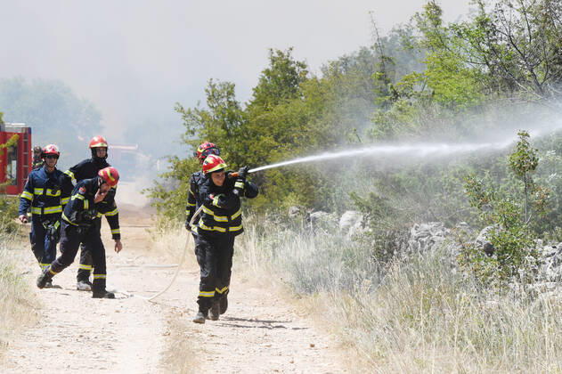 PXL_A fire near Vodice, Croatia Fire in an open area near the Velika Mrdakovica archaeological site in the Vodice hinterland, Croatia on July 13, 2022. About 30 firefighters with a dozen vehicles are on the ground, and two Canadairs joined the ground forces in extinguishing the fire. There are pine forests above, low vegetation, and endangered buildings. HrvojexJelavic PIXSELL