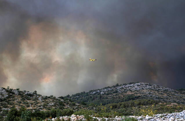 PXL_A fire near Zaton, Croatia Fire in an open area near the Zaton site in the Vodice hinterland, Croatia on July 13, 2022. About 30 firefighters with a dozen vehicles are on the ground, and two Canadairs joined the ground forces in extinguishing the fire. There are pine forests above, low vegetation, and endangered buildings. DuskoxJaramaz PIXSELL