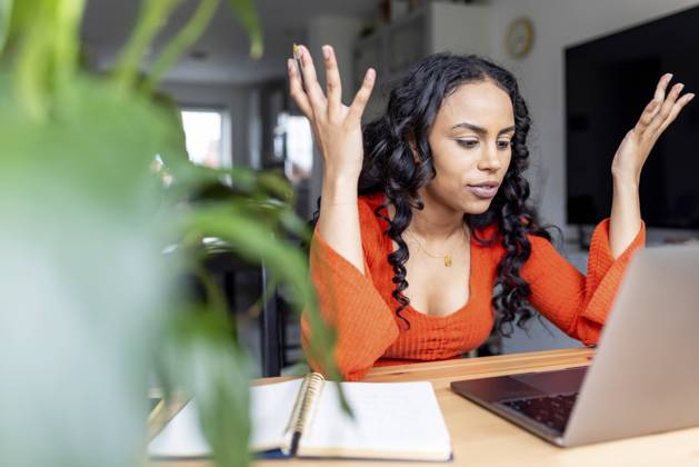 Woman gesturing and talking on video call over laptop at home office model released, Symbolfoto property released, WPEF05993