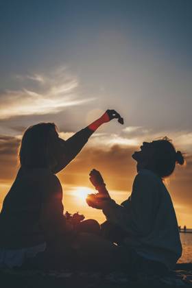 Mother feeding strawberry to daughter at beach model released, Symbolfoto, OMIF00945