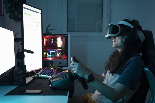 IMAGO Creative, Lifestyle, Gaming Man wearing VR glasses using steering wheel sitting at home model released, Symbolfoto property released, DAMF00999