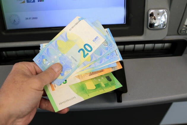 Bargeldversorgung aus einem Automat Eine Person holt an einem Geldautomaten eine größere Menge Bargeld in 50 und 20 Euro Geldscheinen ab