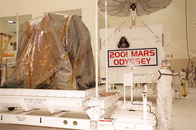 Workers in the Spacecraft Assembly and Encapsulation Facility 2 move the shipping crate away from the 2001 Mars Odyssey spacecraft, at left on the stand. Odyssey is still covered by a protective sheet. The spacecraft, which arrived from Denver, Colo., Jan. 4, will undergo final assembly and checkout in the SAEF-2. That includes installation of two of the three science instruments, integration of the three-panel solar array, and a spacecraft functional test. Launch aboard a Boeing Delta II launch vehicle from Pad A, Complex 17, CCAFS, is planned for April 7, 2001 the first day of a 21-day planetary window. The spacecraft will arrive at Mars on Oct. 20, 2001, for insertion into an initial elliptical capture orbit. Its final operational altitu Copyright: xpiemagsx piemagsspace-16267 !ACHTUNG AUFNAHMEDATUM GESCHÄTZT!