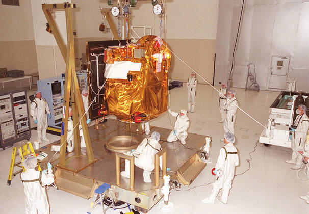 In the Spacecraft Assembly & Encapsulation Facility -2, workers help guide the <a href=http: mars.jpl.nasa.gov 2001 >2001 Mars Odyssey Orbiter < a>as it is lowered to a workstand. The Mars Odyssey Orbiter carries three science instruments: the Thermal Emission Imaging System (THEMIS), the Gamma Ray Spectrometer (GRS), and the Mars Radiation Environment Experiment (MARIE). THEMIS will map the mineralogy and morphology of the Martian surface using a high-resolution camera and a thermal infrared imaging spectrometer. The GRS will achieve global mapping of the elemental composition of the surface and determine the abundance of hydrogen in the shallow subsurface. The GRS is a rebuild of the instrument lost with the Mars Observer mission. The Copyright: xpiemagsx piemagsspace-16295 !ACHTUNG AUFNAHMEDATUM GESCHÄTZT!