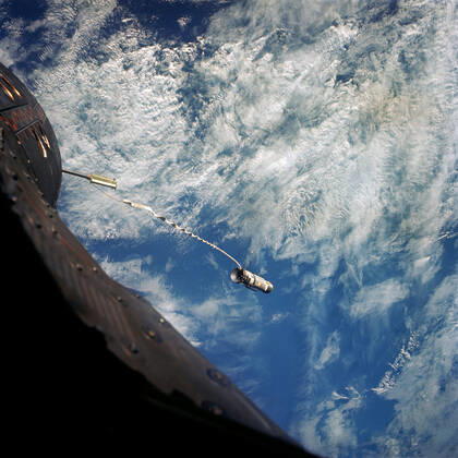 S66-62953 (13 Nov. 1966) --- A 100-foot tether line connects the Agena Target Docking Vehicle with the Gemini-12 spacecraft during its 32nd revolution of Earth. Clouds over the Pacific Ocean are in the background. Copyright: xpiemagsx piemagsspace-54783 !ACHTUNG AUFNAHMEDATUM GESCHÄTZT!