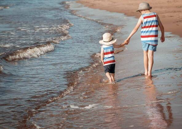  Two brothers are walking on the beach, Two brothers barefoot are walking on the beach in water. Boys are on vacation in summer at the sea, Two brothers barefoot are walking on the beach in water. Boys are on vacation in summer at the sea model released, Symbolfoto , 01.11.2020, Copyright: xcandy18x Panthermedia28989349.jpg