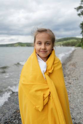 IMAGO Creative: Ende des Sommers Side view of thoughtful girl standing by the sea wrapped in a yellow blanket on a cold day looking at camera, Model released LiliyaSolopova_MayaVaravaraAndVenera_00037.jpg Copyright: xLiliyaxSolopovax MR