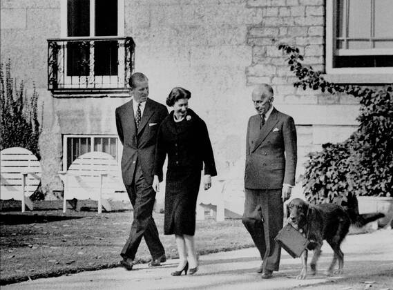 October 15, 1957, OTTAWA, ON, CANADA: Queen Elizabeth II strolls in the gardens at Rideau Hall, accompanied by Governor General Vincent Massey and Prince Philip, in Ottawa, Oct. 15, 1957. Duff , a golden retriever, is carrying her handbag. OTTAWA CANADA - ZUMAc35_ 19571015_zaf_c35_003 Copyright: xPeelx