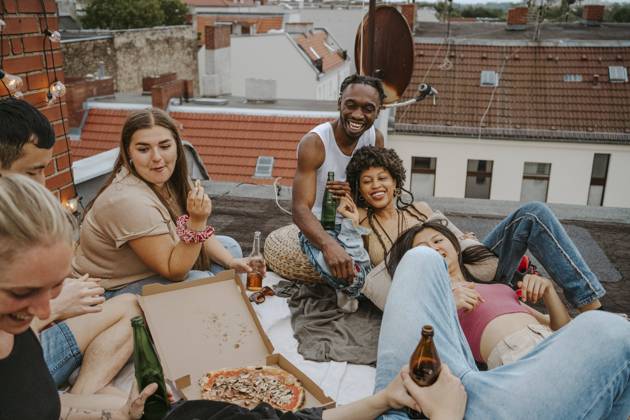 IMAGO Creative, Urban Lifestyle IMAGO Kreativ: Urbane Kultur - Sommer auf den Dächern Happy male and female friends with pizza enjoying party on rooftop Germany, Berlin, model released, property released Copyright: xMaskot,xMaskotxBildbyraxABx , MA95145 MA95145