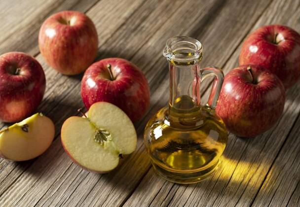  Apple vinegar in a glass container against a wooden background, Apple vinegar in a glass container against a wooden background with lots of apples around it., Apple vinegar in a glass container against a wooden background with lots of apples around it., 10.12.2021, Copyright: xsai0112x Panthermedia30957299.jpg