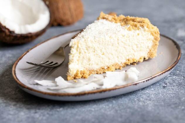 piece of coconut cheesecake on a plate with fresh coconut, piece of coconut cheesecake on a plate with fresh coconut., piece of coconut cheesecake on a plate with fresh coconut., 01.08.2022, Copyright: xIvannax Panthermedia31661926.jpg