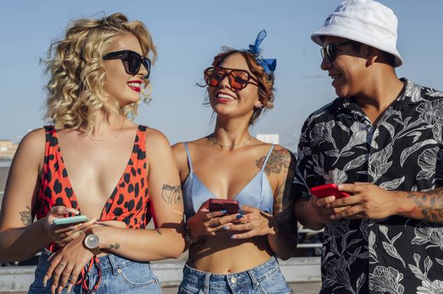 Man and women with mobile phones standing together on sunny day model released, Symbolfoto property released, PGF01257