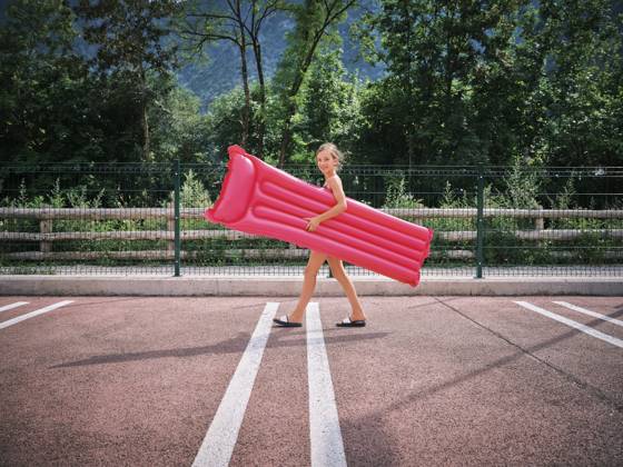 Smiling girl walking with pink inflatable pool raft on sunny day model released, Symbolfoto, DIKF00699