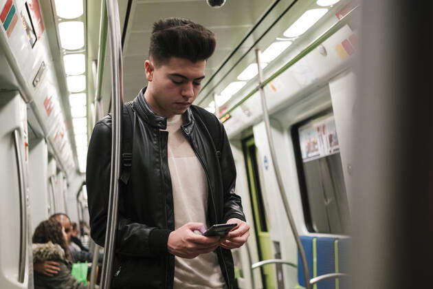 Young man using smart phone in subway train model released, Symbolfoto, EGAF02574
