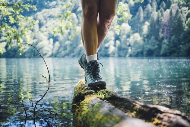 Woman wearing hiking boot walking on tree log by Lake Levico model released, Symbolfoto, GIOF15589