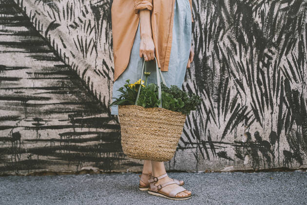 Woman with leafy vegetables and flowers in wicker bag by patterned wall model released, Symbolfoto, NDEF00015