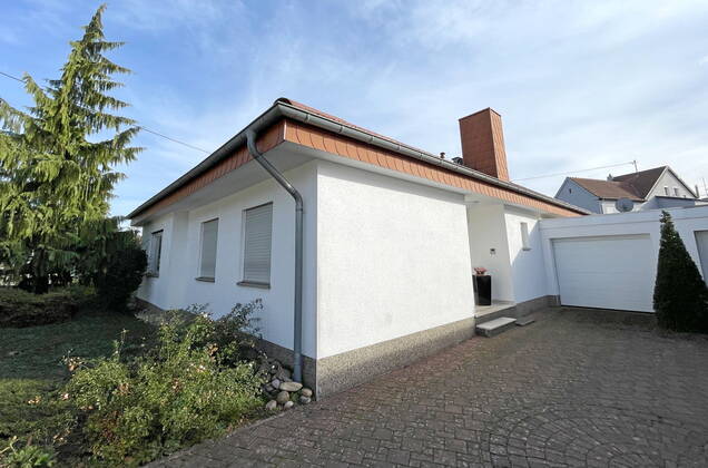 In diesem Bungalow in der Straße Im Herrnkreth in Heusweiler-Niedersalbach lebte die, seit 19. September vermisste, Gerda Schuster (74), hier fotografiert am Dienstag (08.11.2022). Die alleinstehende Frau soll nach Angaben der Polizei umgebracht worden sein. Die Rollläden am Anwesen sind noch heruntergelassen, weil die Seniorin vor ihrem Tod mit der mutmaßlichen späteren Täterin in Urlaub fuhr. An der Haustür klebt eine Visitenkarte der Polizei, offensichtlich hat die Spurensicherung Teile der Türlackierung abgekratzt.