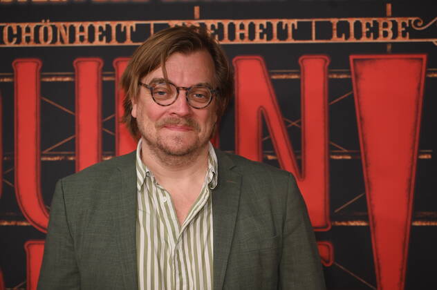 Moderator Nilz Bokelberg kommt über den roten Tepich bei der Galapremiere des Musical Moulin Rouge! Das Musical in den Kölner Musical Dome